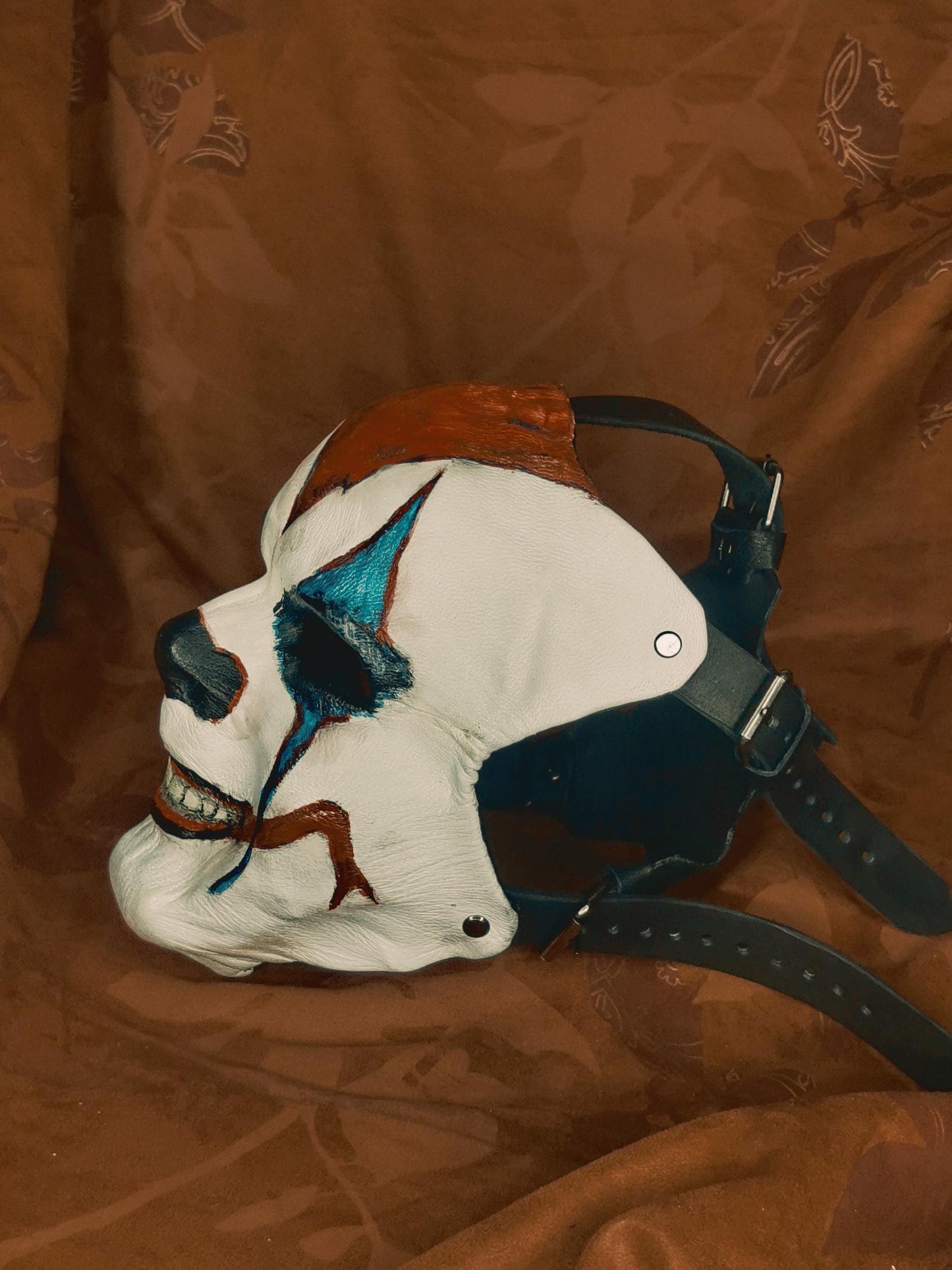 White Leather Mask "Trickster Clown" , with coloring, with five strap-system, red mouth, blue diamonds eyes outline, black normal nose.