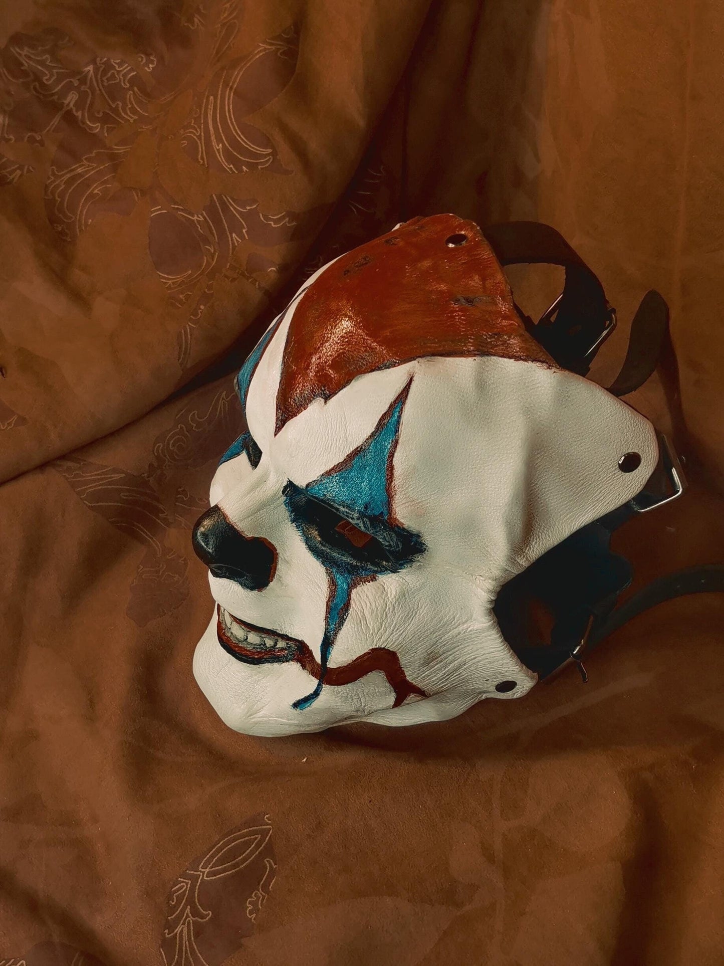 White Leather Mask "Trickster Clown" , with coloring, with five strap-system, red mouth, blue diamonds eyes outline, black normal nose.